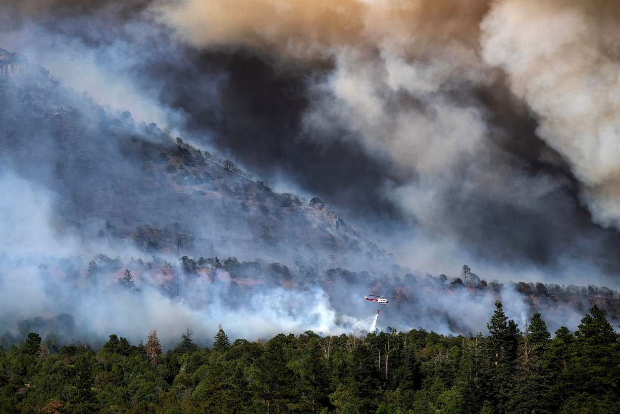 A helicopter provides bucket drops to assist firefighters battling the Gold Mountain Fire on the town line of Ouray and Ridgeway, Colo., June 28. Over 100 Uncompahgre cutthroats were rescued from Nate Creek, which was in the direct path of the blaze.