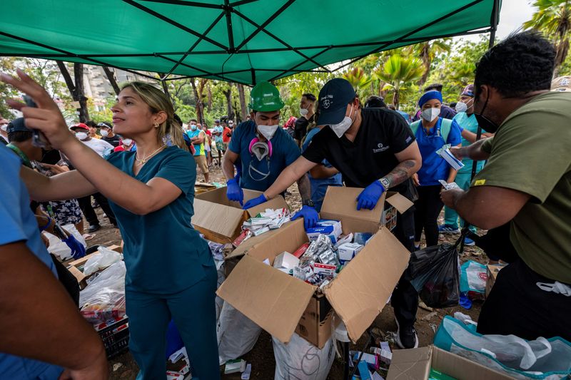Medical staff and students sort medicines to distribute to displaced people at a park in Caraballeda, La Guaira state, Venezuela, Tuesday. Thousands remain missing as rescue efforts continue.