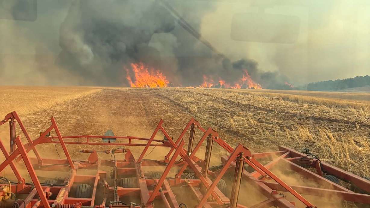 Zach Johnson discing his wheat field as the Horse Head Fire grows.