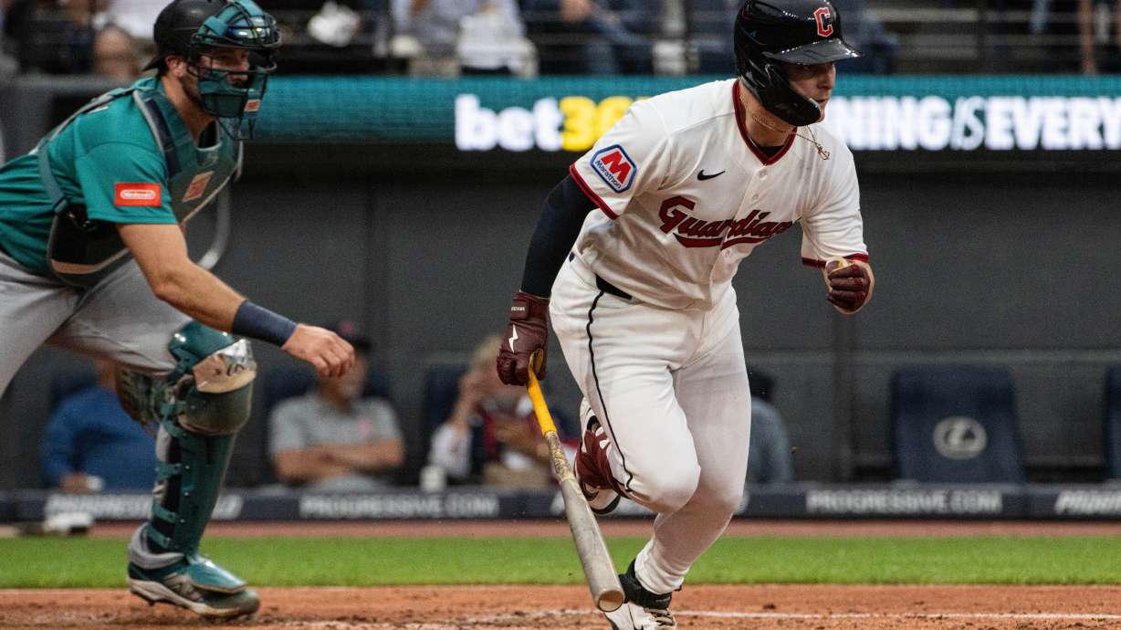 Cleveland Guardians' Cooper Ingle watches his first Major League hit, a two-run single off Seattle Mariners starting pitcher Logan Gilbert as Cal Raleigh moves into position during the third inning of a baseball game, Saturday, June 27, 2026, in Cleveland. CORRECTION: Corrects to a two-run single not an RBI single