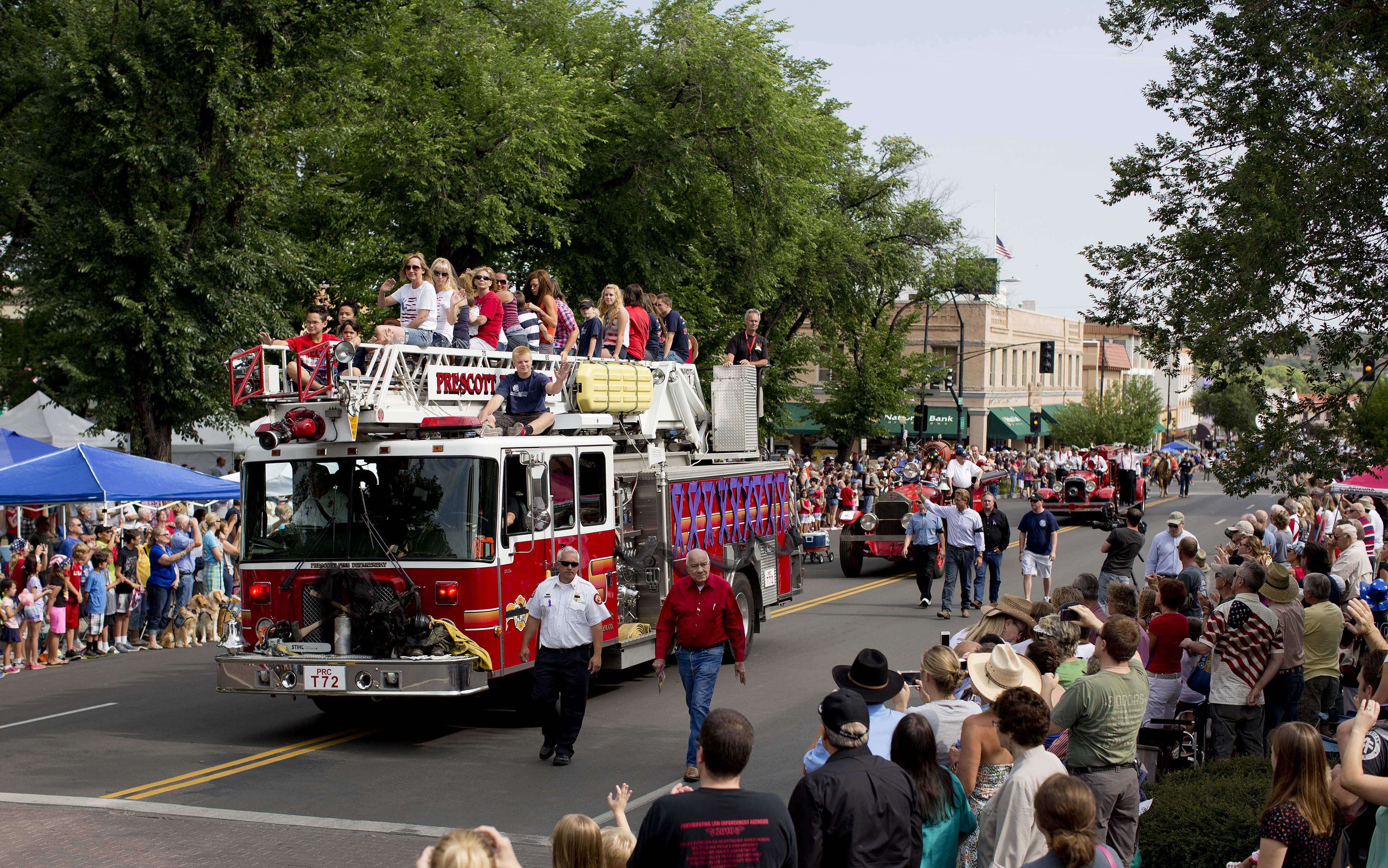 Carrying family members of the 19 fallen Granite Mountain Hotshot firefighters, a Prescott Fire Department fire engine makes its way down Cortez Street during the Prescott Frontier Days Rodeo Parade, July 6, 2013, in Prescott, Ariz.