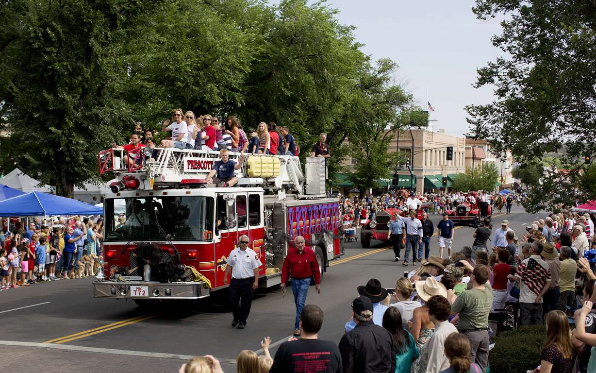 Carrying family members of the 19 fallen Granite Mountain Hotshot firefighters, a Prescott Fire Department fire engine makes its way down Cortez Street during the Prescott Frontier Days Rodeo Parade, July 6, 2013, in Prescott, Ariz.