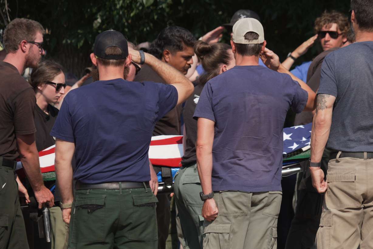 The body of a firefighter who died battling wildfires near the Colorado-Utah border is carried during a procession in Grand Junction, Colo., Monday. Three firefighters were killed and two more were injured in the Snyder Fire.