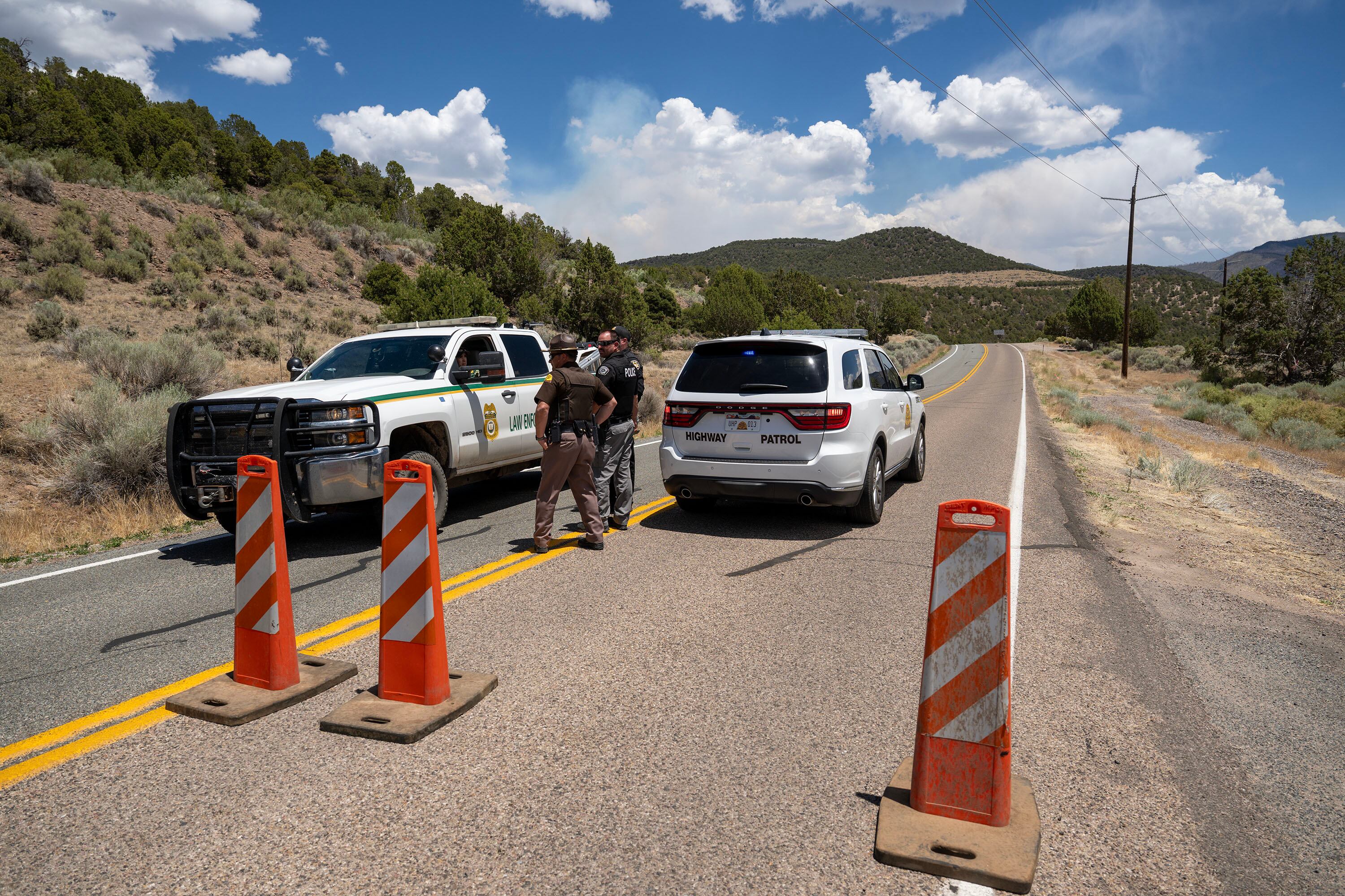 Rangers and Highway Patrol Troopers talk at a road block on state Road 153 toward Beaver Canyon as the Cottonwood Fire continues to burn east of Beaver on Tuesday. Utahns are coming together to support those affected by this summer's fires.