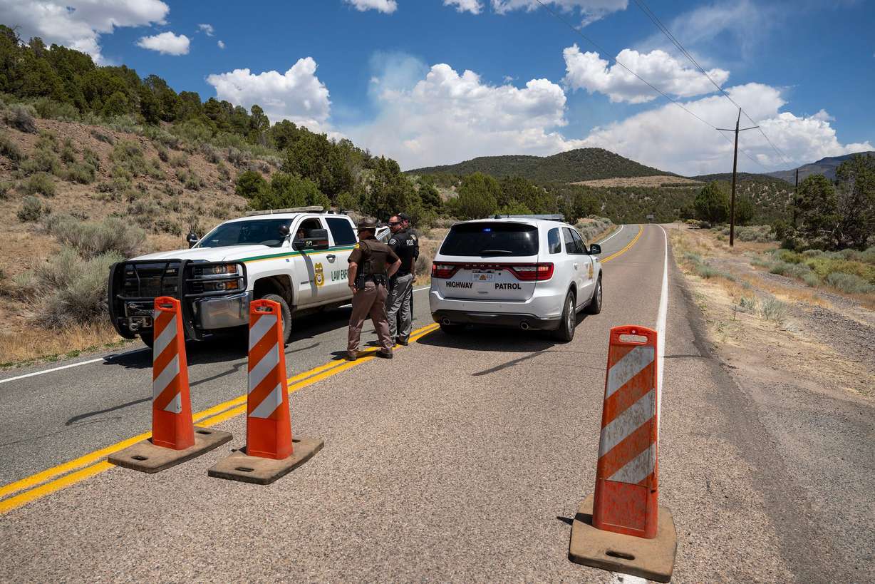 Rangers and Highway Patrol Troopers talk at a road block on state Road 153 toward Beaver Canyon as the Cottonwood Fire continues to burn east of Beaver on Tuesday. Utahns are coming together to support those affected by this summer's fires.