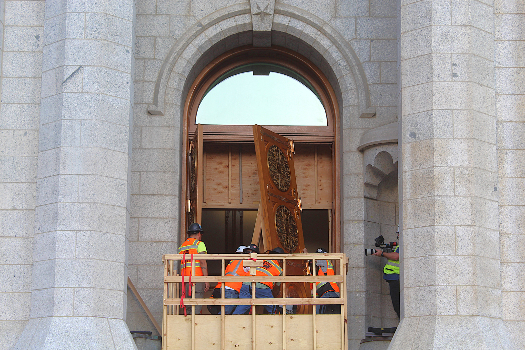 Crews reinstall one of the east doors on the Salt Lake Temple of The Church of Jesus Christ of Latter-day Saints on June 24.