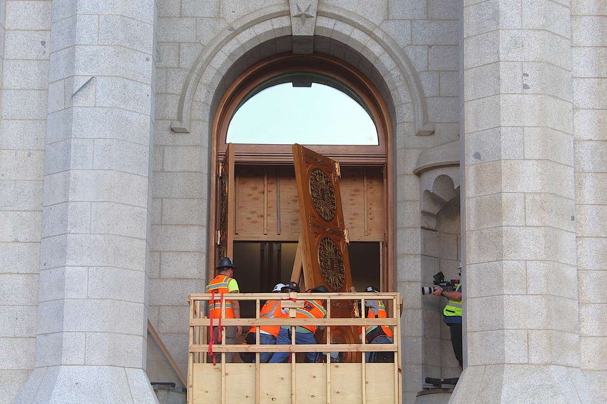 Crews reinstall one of the east doors on the Salt Lake Temple of The Church of Jesus Christ of Latter-day Saints on June 24.