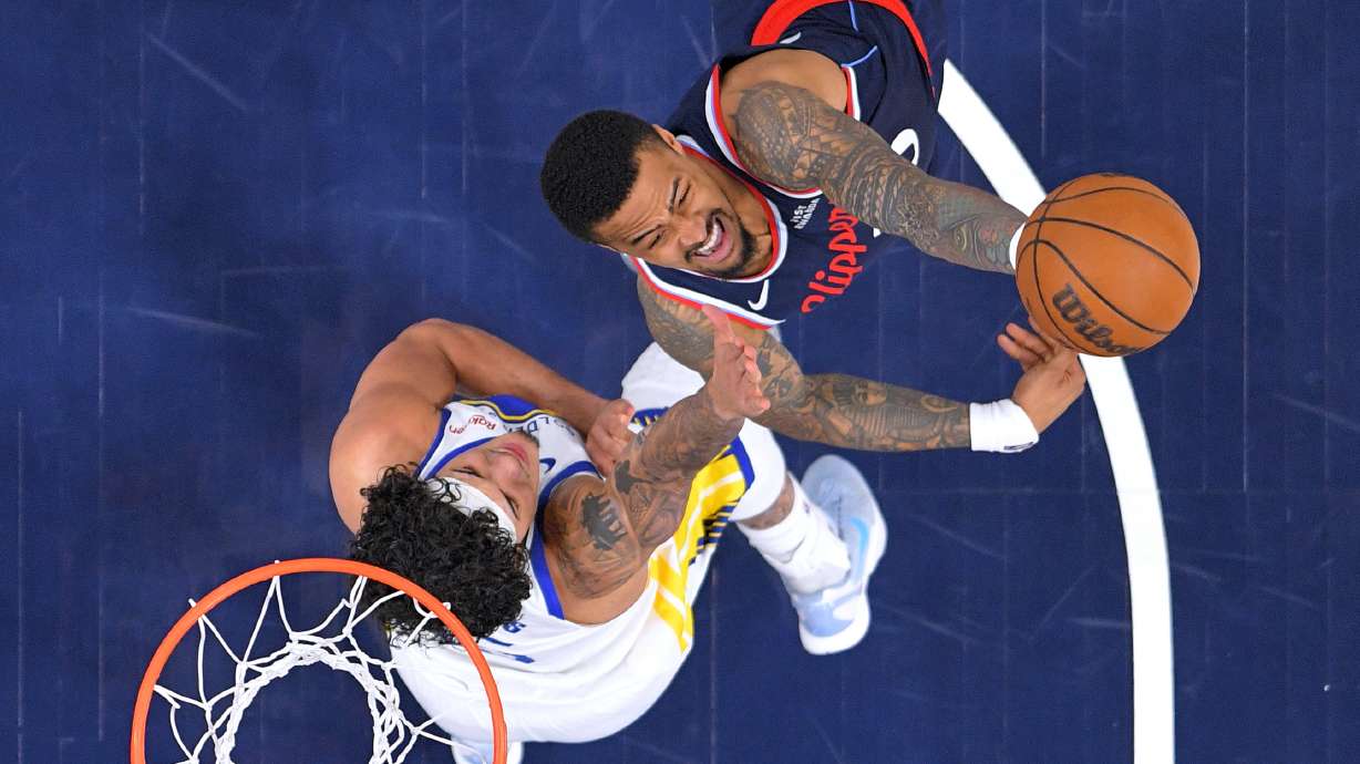 FILE - LA Clippers forward John Collins, right, shoots as Golden State Warriors forward Gui Santos defends during the first half of an NBA play-in tournament basketball game April 15, 2026, in Inglewood, Calif.
