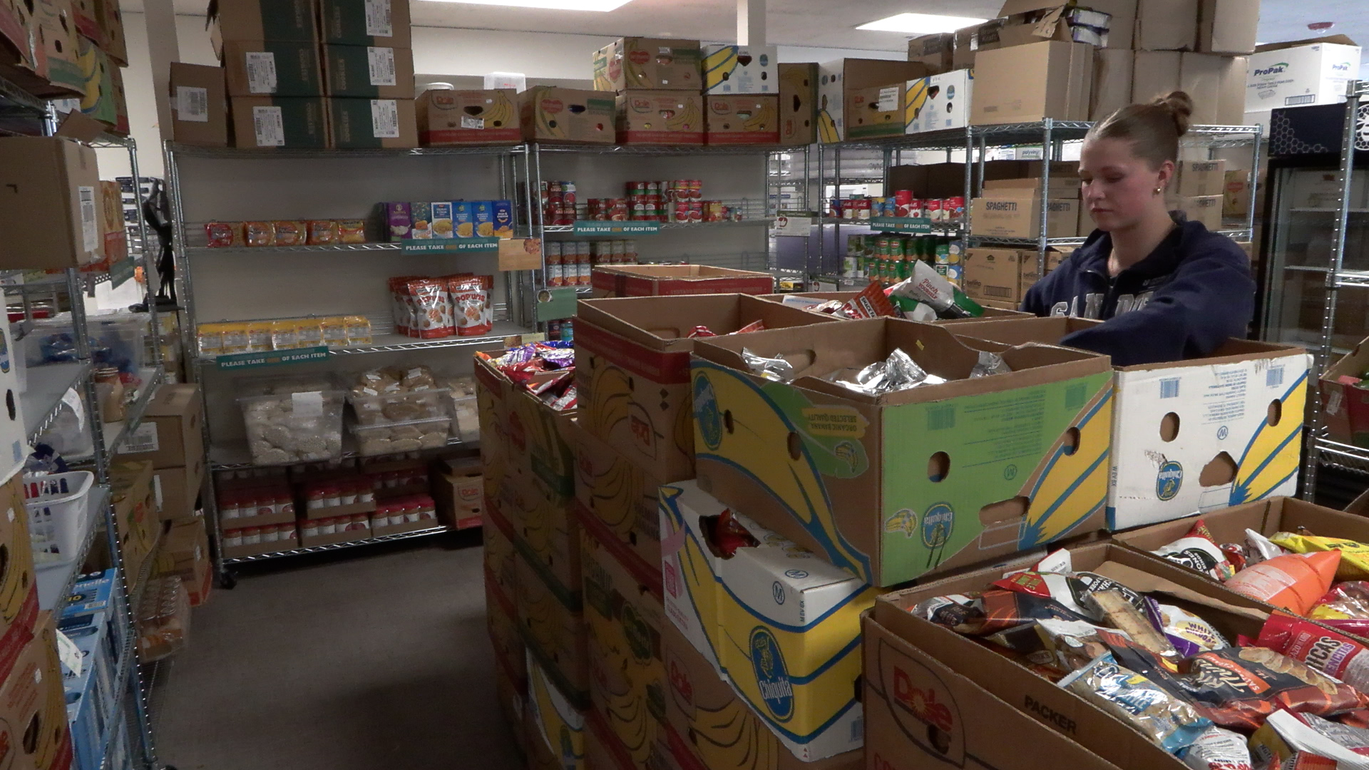 An employee at SNAC sorts food donations, Monday.