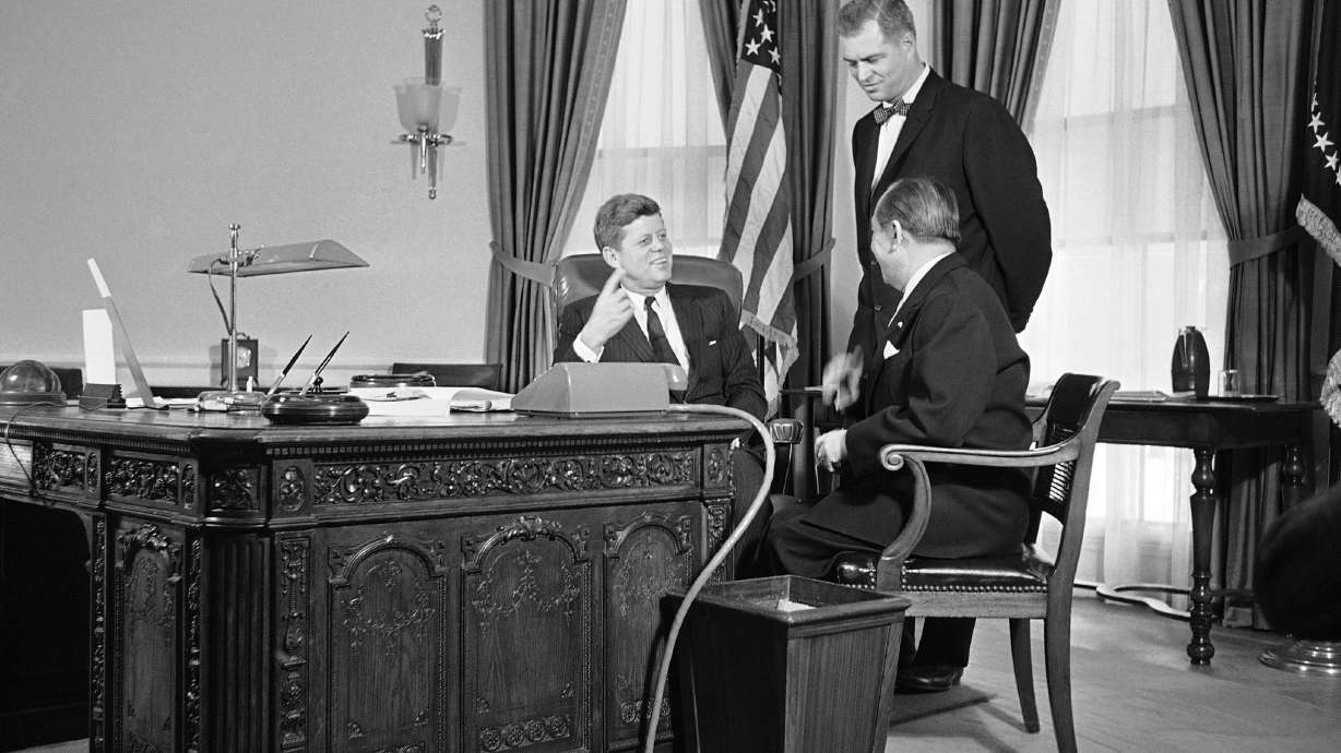 President John F. Kennedy gestures from behind a richly carved desk, made from the timbers of a British sailing ship, as he talks, Feb. 6, 1961. The Resolute Desk is one of the most recognizable pieces of furniture in the White House — and probably in the entire nation