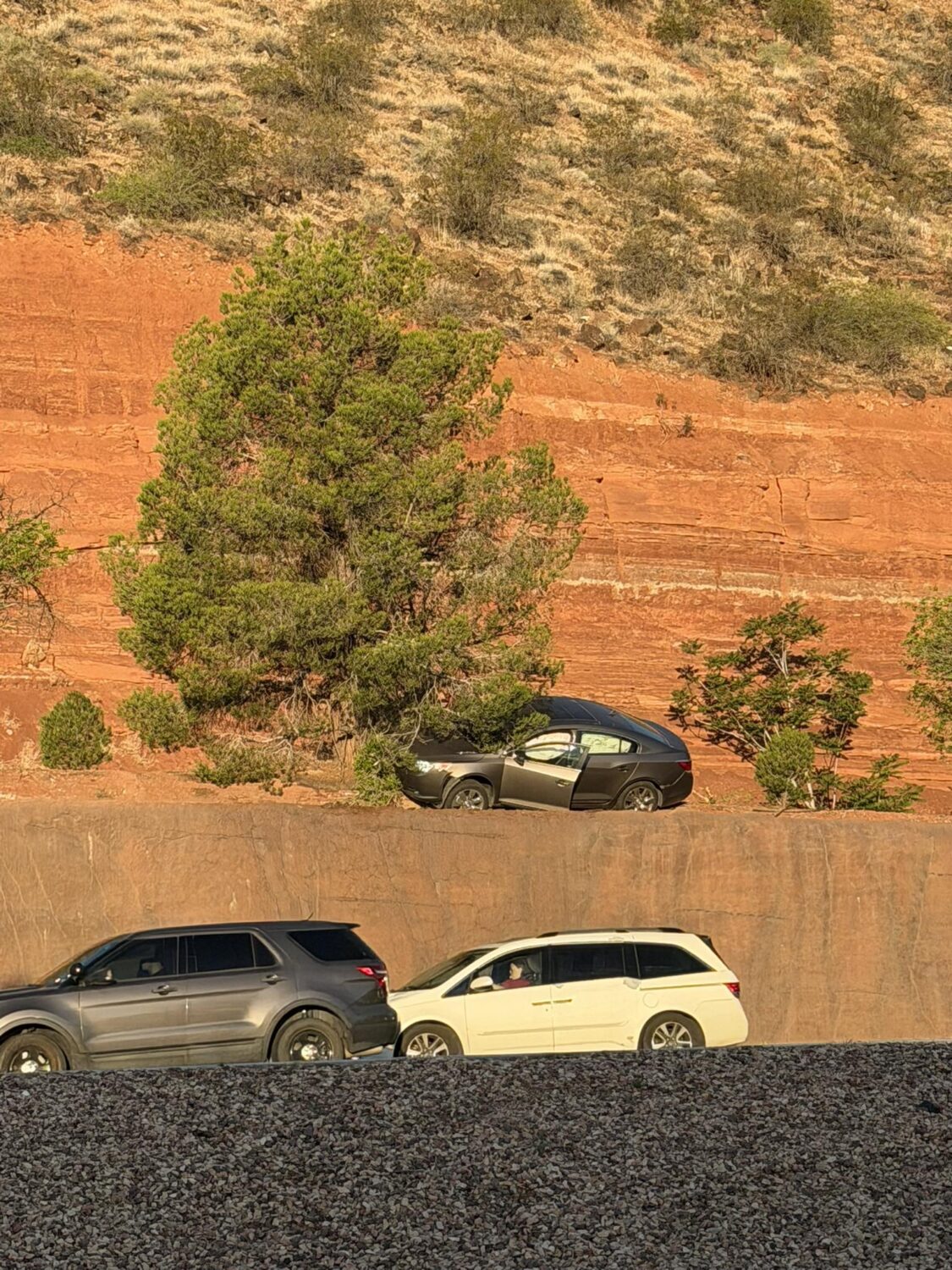 Driver arrested after crashing, nearly going off small cliff into traffic