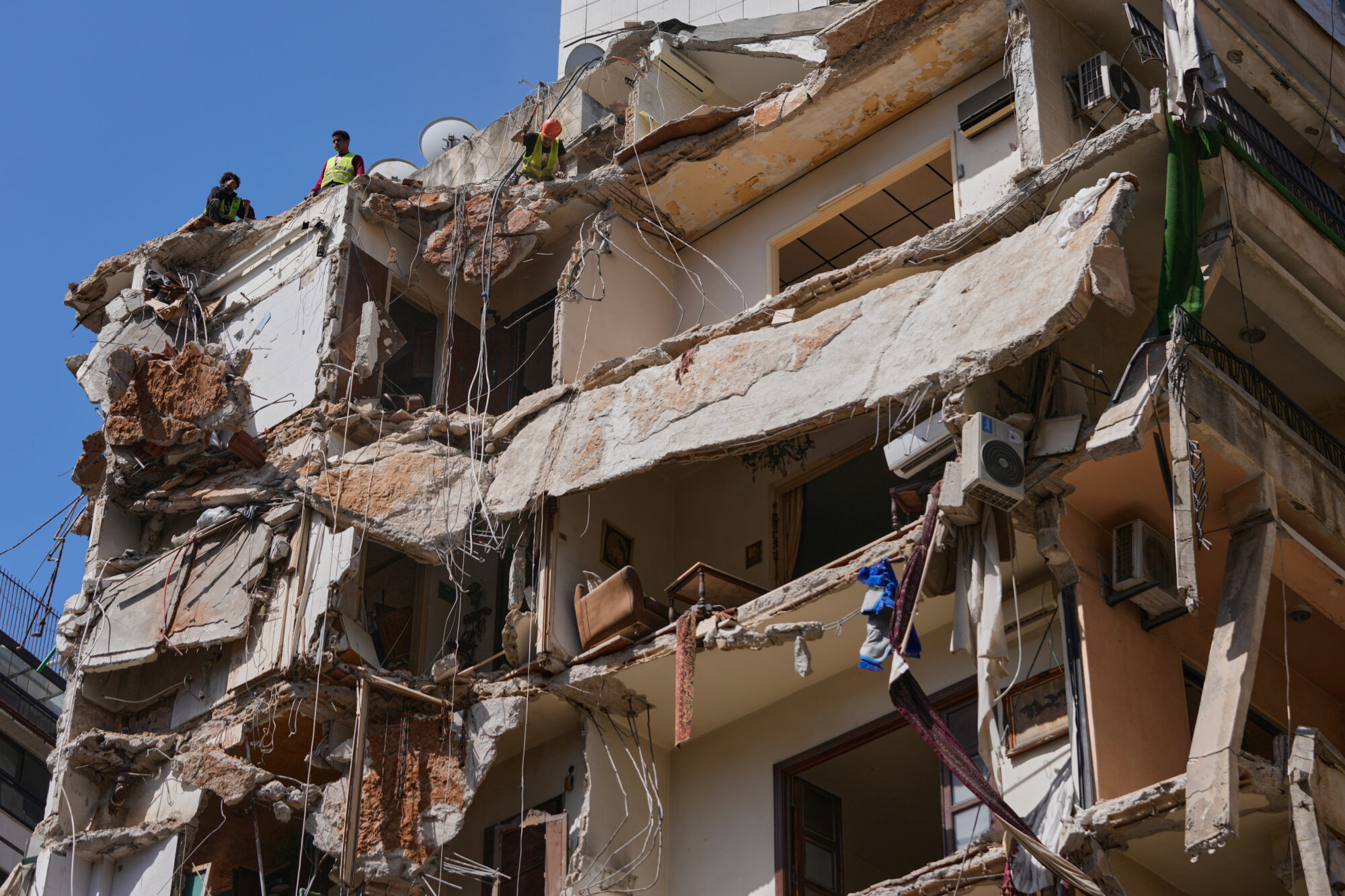 Workers remove the rubble as rescuers keep searching for a missing woman and girl at a destroyed building that was hit on April 8, in an Israeli airstrike in Beirut, Lebanon, Monday, April 13, 2026.