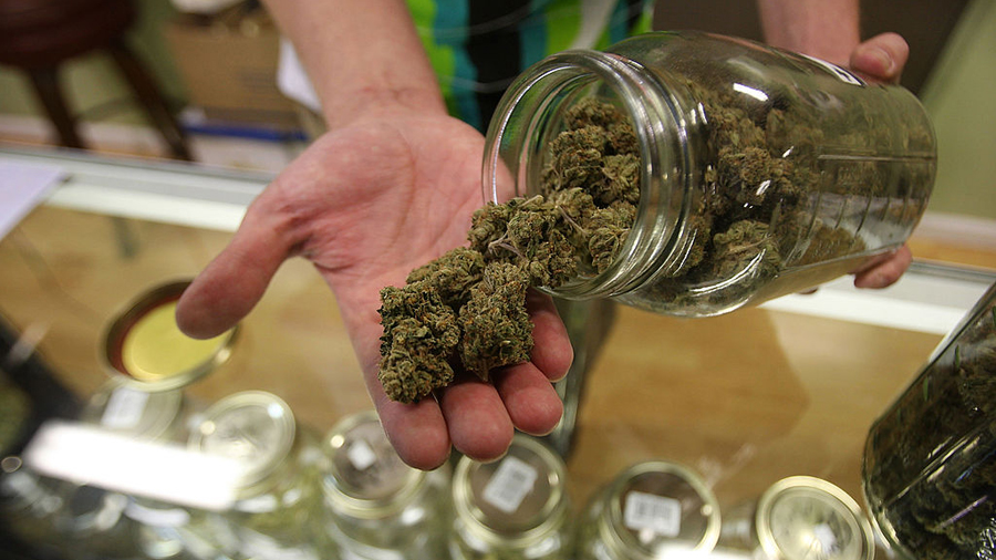Dave Warden, a bud tender at Private Organic Therapy (P.O.T.), a non-profit co-operative medical marijuana dispensary, displays various types of marijuana available to patients.