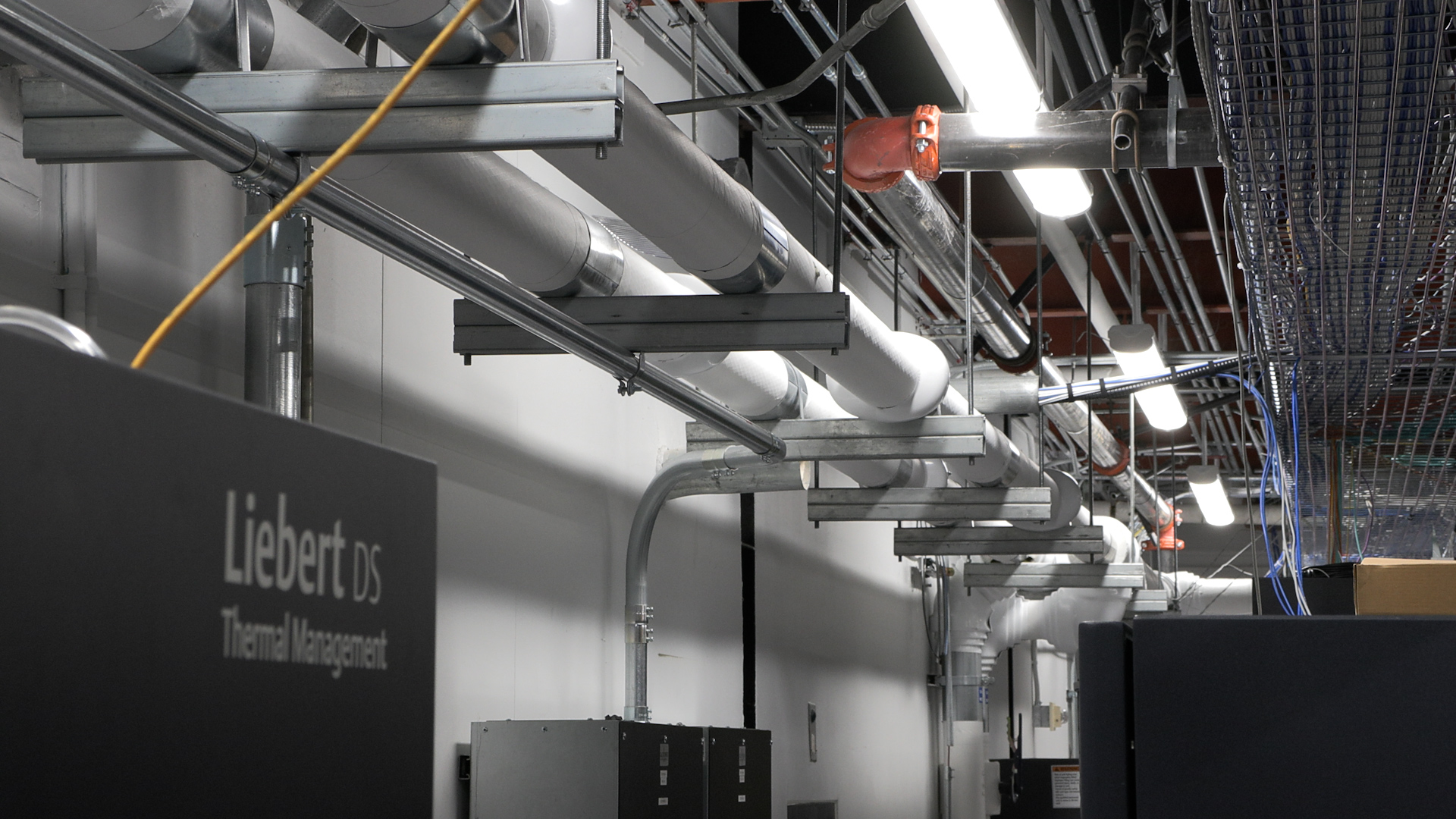 A set of pipes exchange heated and cooled water inside a small data center at the University of Utah. 