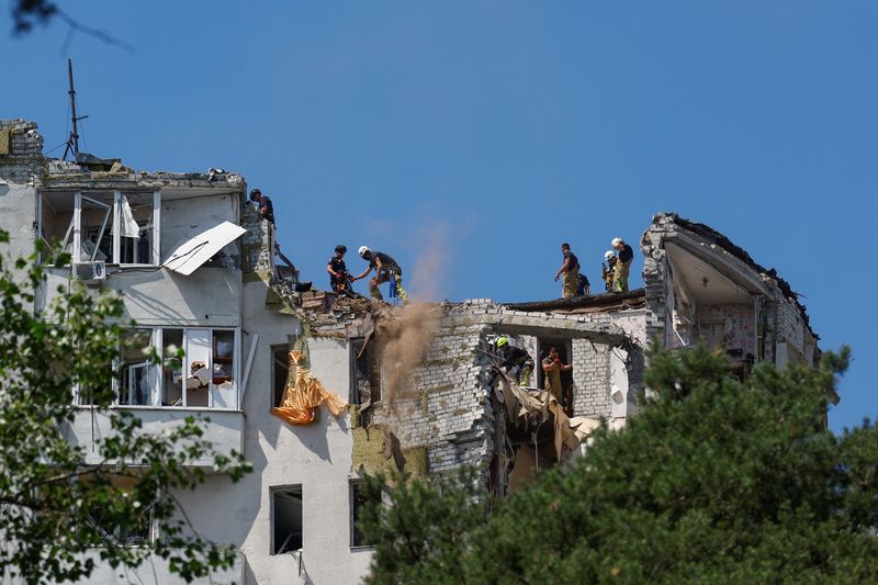 Rescuers work atop an apartment building damaged during overnight Russian missile and drone strikes, amid Russia's attack on Ukraine, in Kyiv, Thursday. The death toll from the attack stood at 21 as of Thursday night.