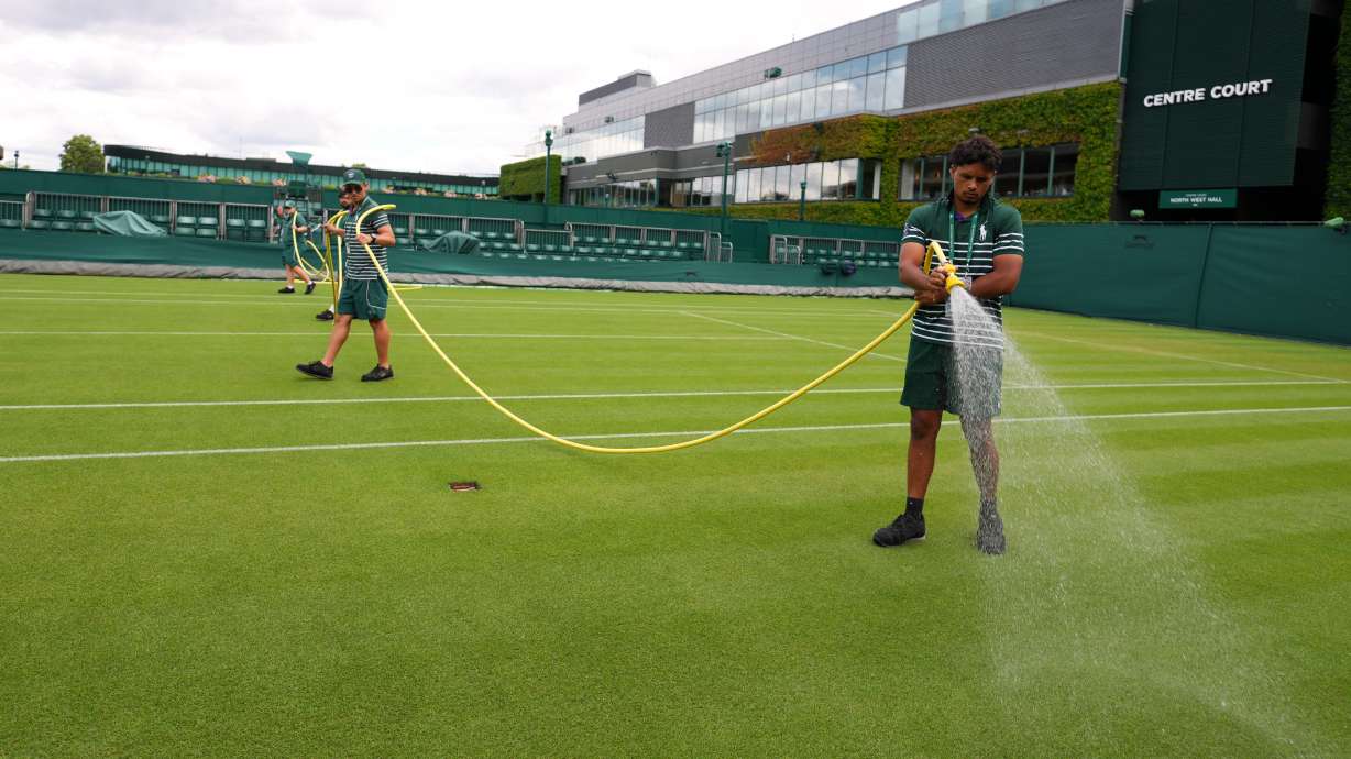 Ground staff waters a court one day ahead of the start of the Wimbledon Tennis Championships in London, Sunday, June 28, 2026.