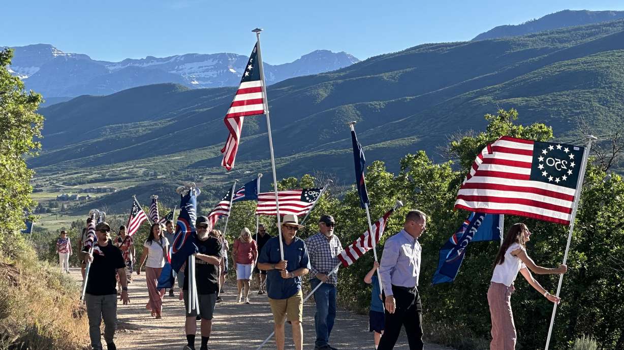Community members install commemorative flags on Memorial Hill as part of Midway's Memorial Hill Flag Legacy Event on June 15.