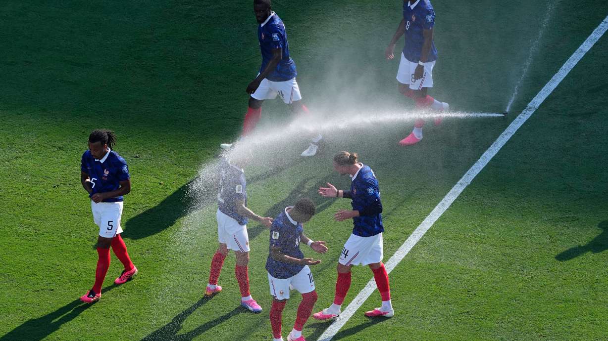 French players cool off from field sprinklers during the World Cup round of 32 soccer match against Sweden in East Rutherford, N.J., near New York, Tuesday, June 30, 2026.