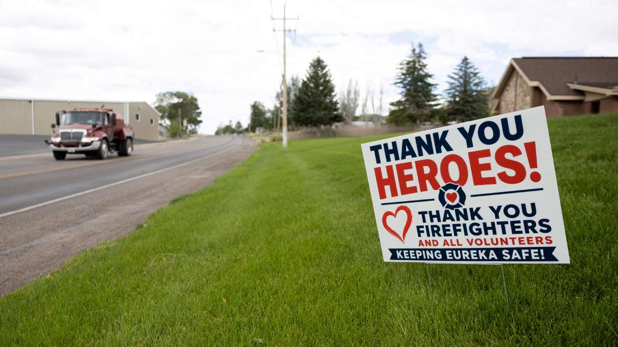A sign thanking firefighters in the grass near U.S. 6 in Eureka as residents return to their homes on June 28. Firefighters said Friday they're nearing full containment of the Iron and Cherry fires near the city.