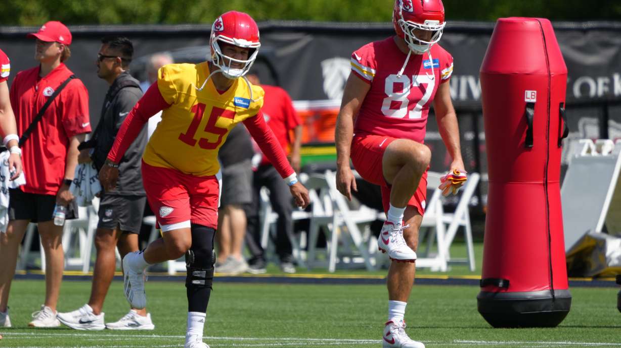 Kansas City Chiefs quarterback Patrick Mahomes (15) and tight end Travis Kelce (87) stretch out during the NFL football team's practice Tuesday, June 9, 2026, in Kansas City, Mo.