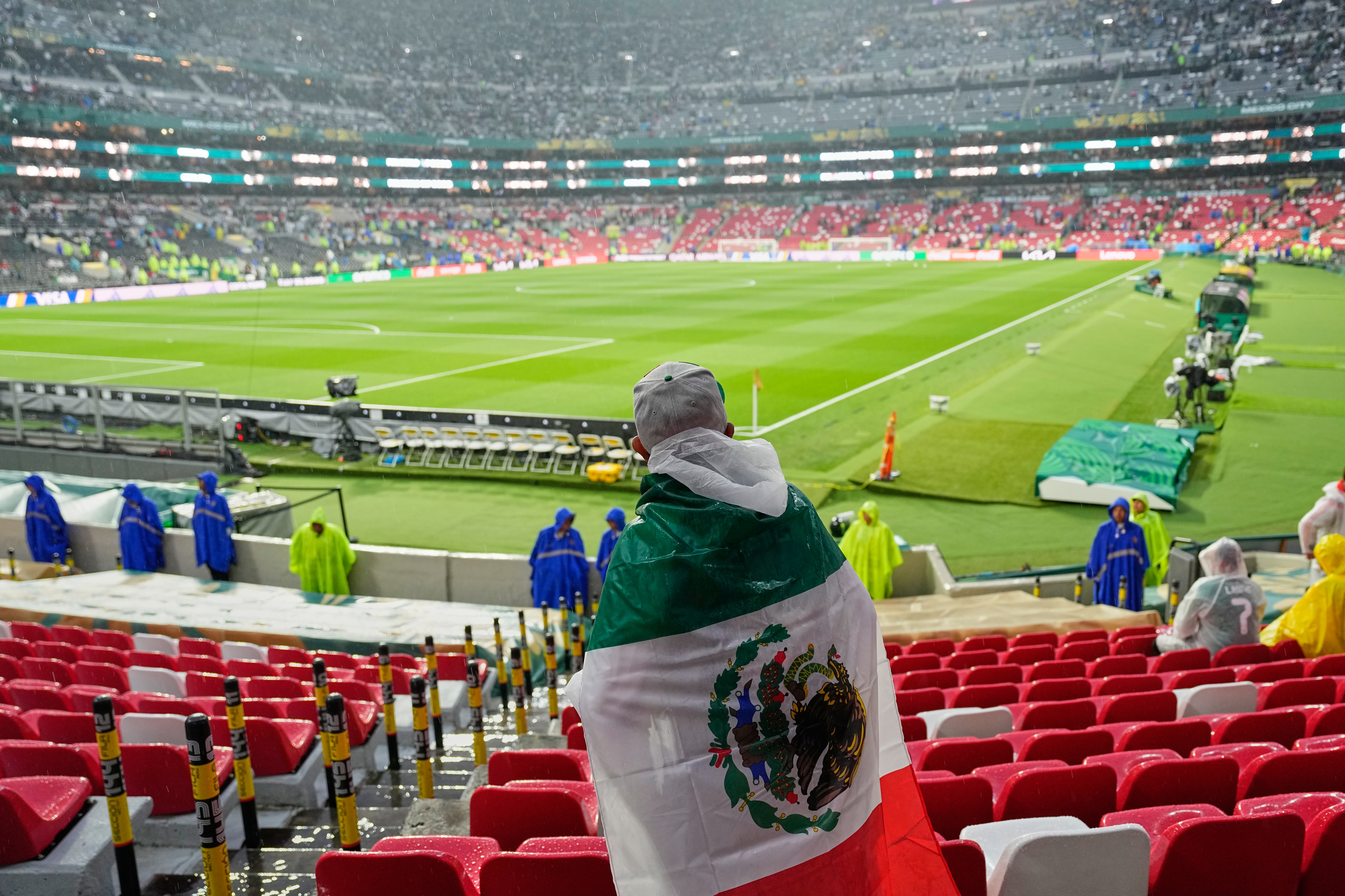 A Mexican fan waits in the rain for the start of the World Cup round of 32 soccer match between Mexico and Ecuador in Mexico City, Tuesday, June 30, 2026. 