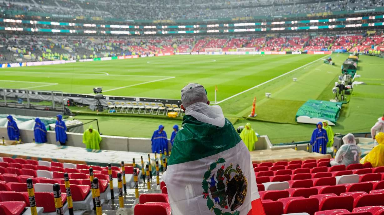 A Mexican fan waits in the rain for the start of the World Cup round of 32 soccer match between Mexico and Ecuador in Mexico City, Tuesday, June 30, 2026.