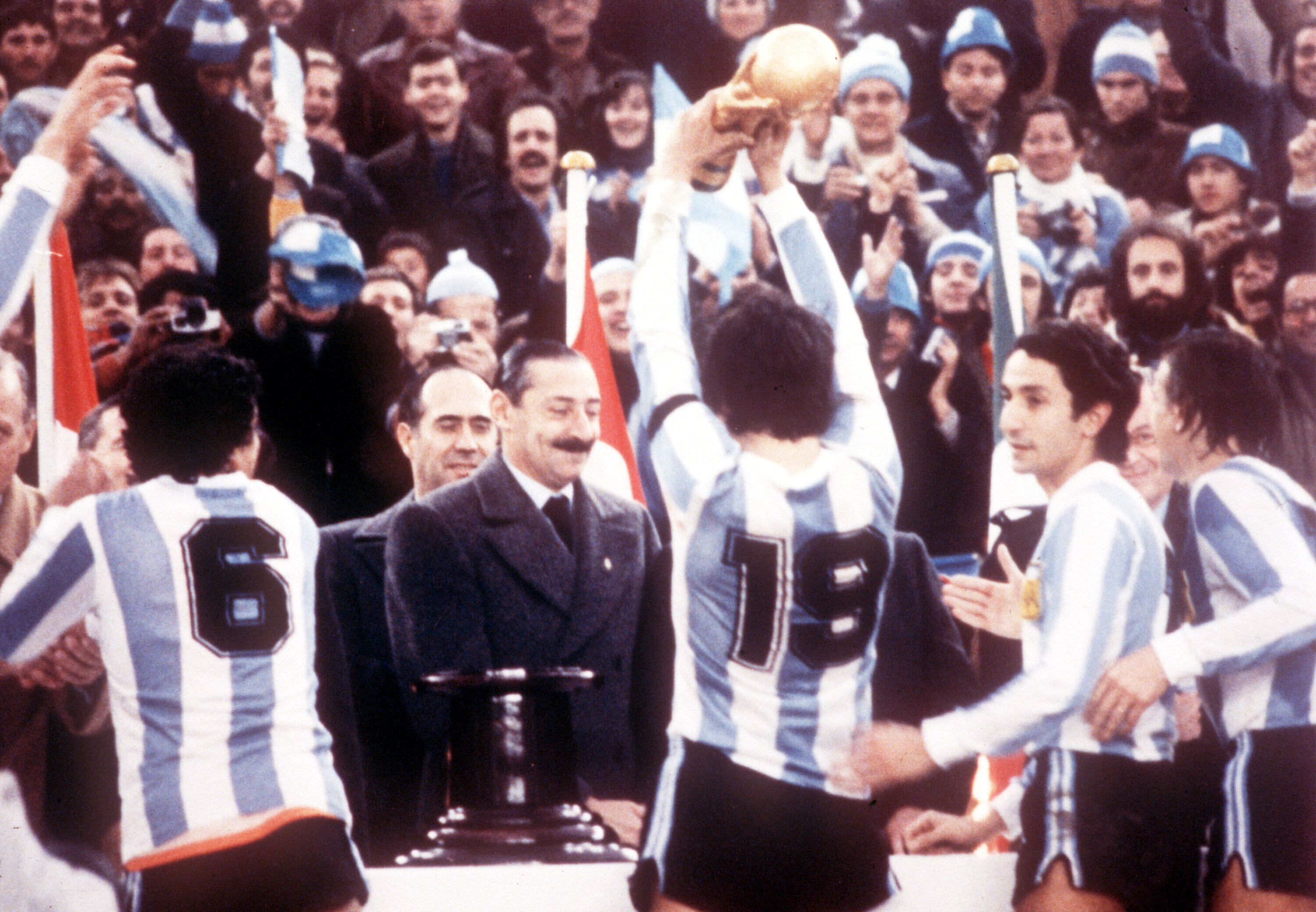FILE - Argentine President Jorge Rafael Videla, center, looks on after he presented the World Cup Trophy to Argentina's captain Daniel Passarella (19), at the presentation ceremony following the World Cup final soccer match against the Netherlands in the River Plate Stadium in Buenos Aires, June 25, 1978. 