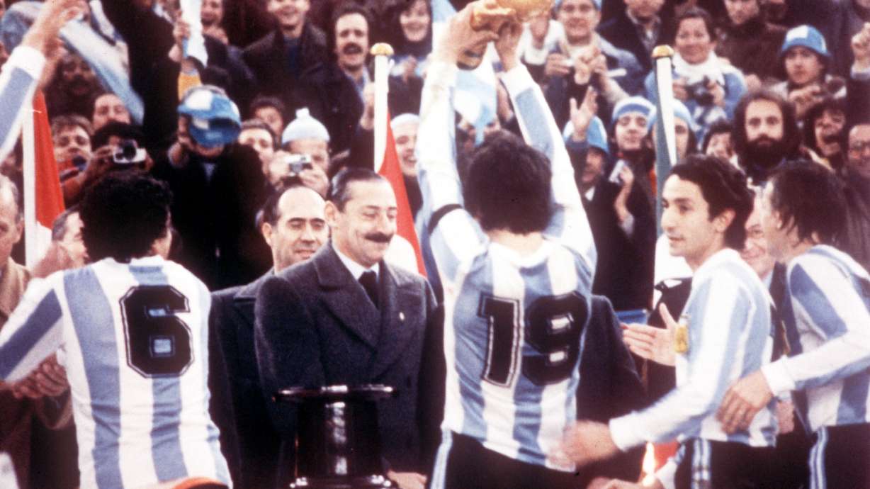 FILE - Argentine President Jorge Rafael Videla, center, looks on after he presented the World Cup Trophy to Argentina's captain Daniel Passarella (19), at the presentation ceremony following the World Cup final soccer match against the Netherlands in the River Plate Stadium in Buenos Aires, June 25, 1978.
