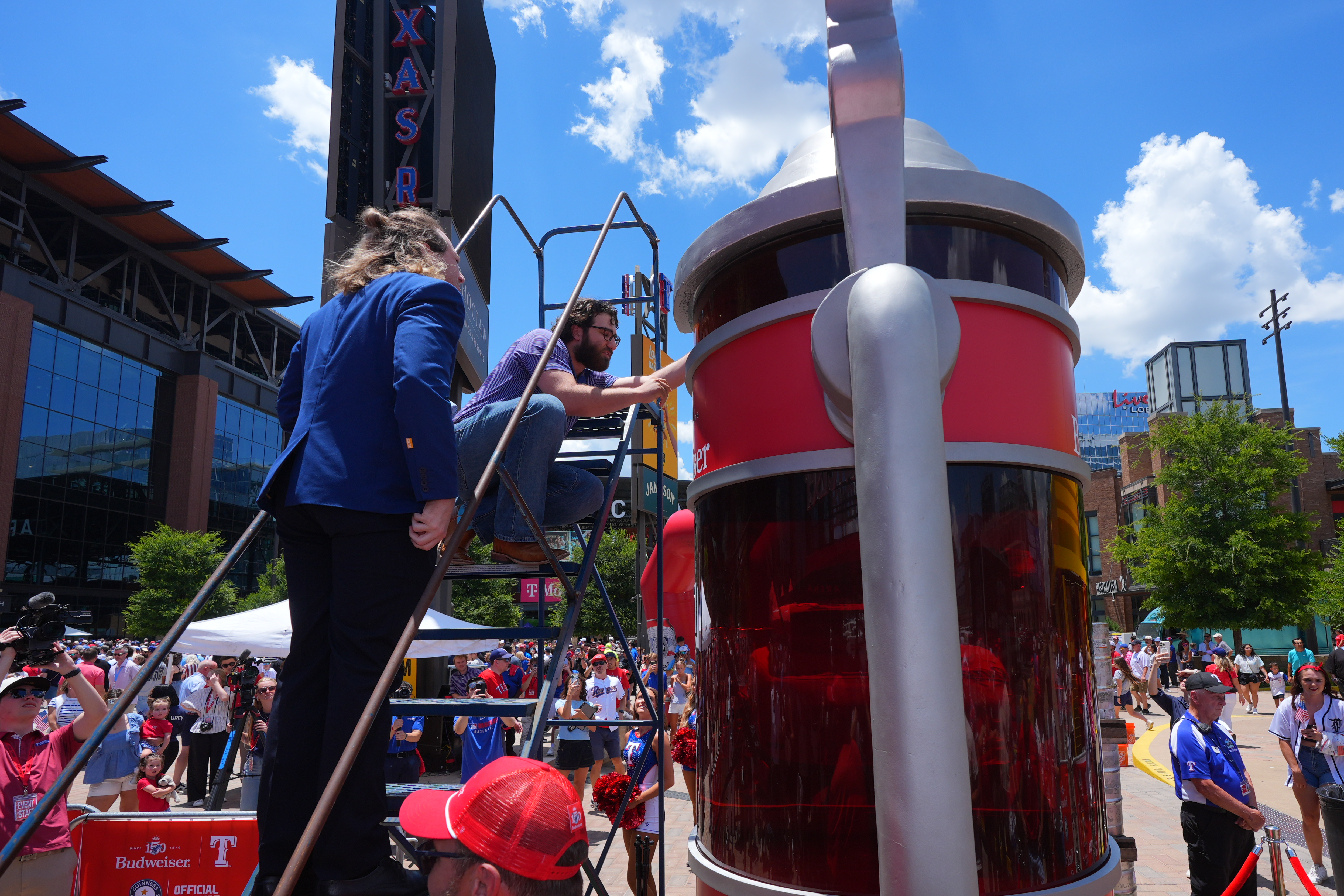 Eric Johnson and Guinness World Records adjudicator Thomas Bradford check the level of beer before certifying a world record for Largest Glass of Beer ahead of a baseball game between the Detroit Tigers and Texas Rangers, Saturday, July 4, 2026, in Arlington, Texas. 