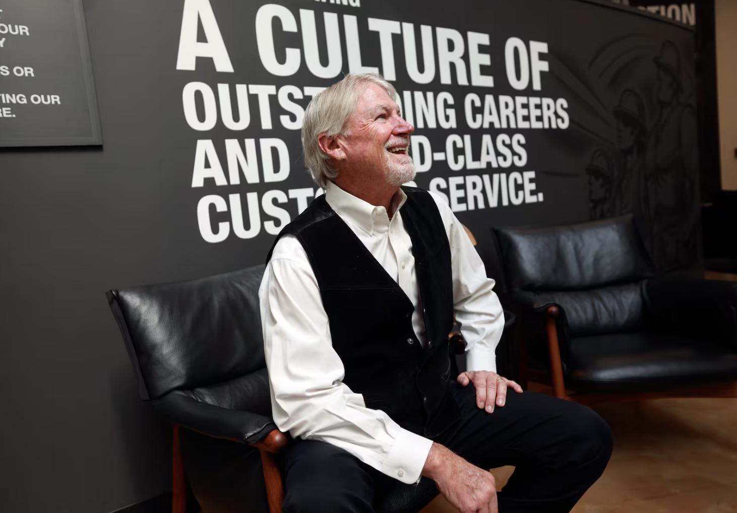 Rob Moore, Big-D executive chairman, talks with a passing employee during a portrait shoot at the Big-D office in Salt Lake City on May 19. Moore has been with the company for 50 years.