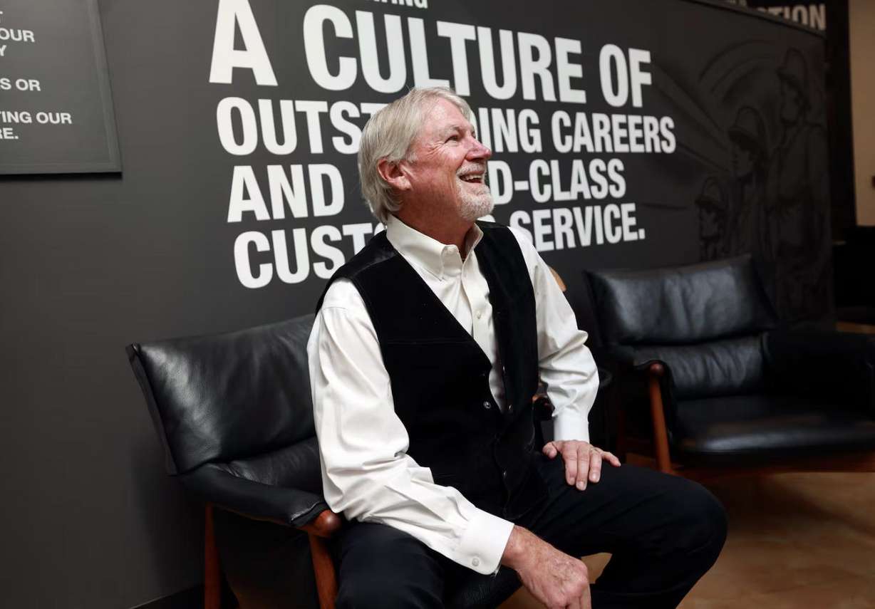Rob Moore, Big-D executive chairman, talks with a passing employee during a portrait shoot at the Big-D office in Salt Lake City on May 19. Moore has been with the company for 50 years.