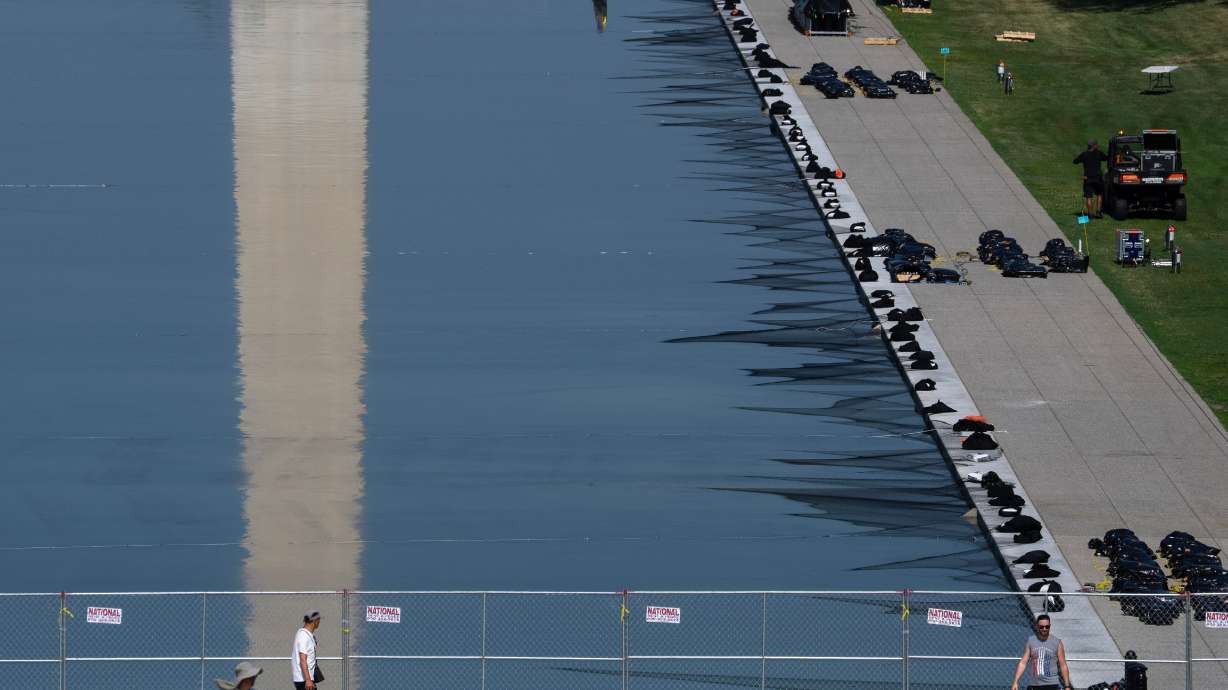 Workers install fireworks along the edge of the Lincoln Memorial Reflecting Pool ahead of the America 250 July 4th celebration on the National Mall, Thursday, in Washington. The Trump administration won't seek new bids to repair the pool.