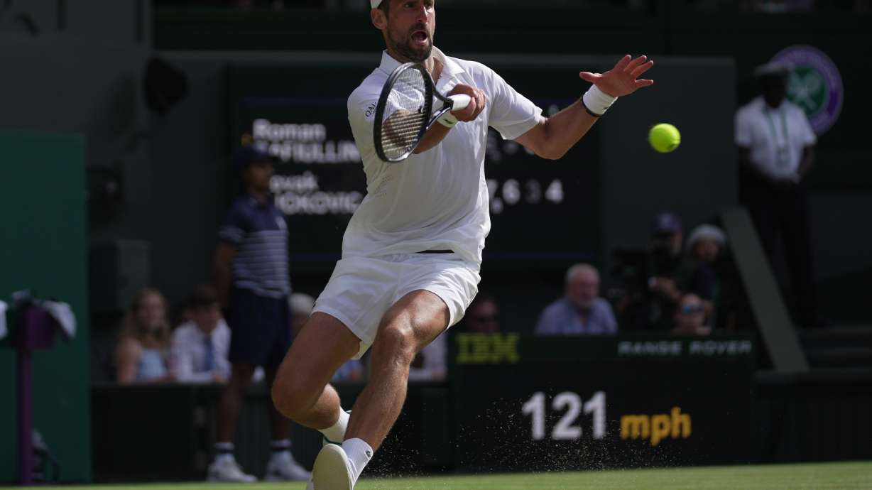 Novak Djokovic of Serbia returns the ball to Roman Saffiulin of Russia in their fourth round men's singles match at the Wimbledon Tennis Championships in London, Sunday, July 5, 2026.
