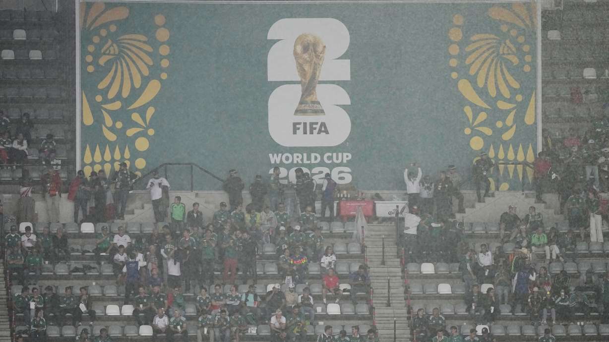 Fans wait out the rain as the game between Mexico and England is delayed due to weather for the World Cup round of 16 soccer match in Mexico City, Sunday, July 5, 2026.