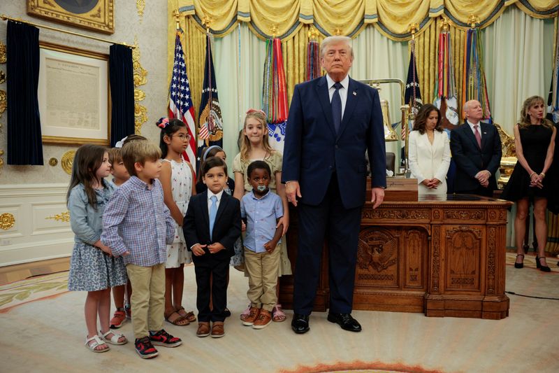Children pose with President Donald Trump during an event to mark the launch of "Trump Accounts" in the Oval Office at the White House in Washington, D.C., Monday. 