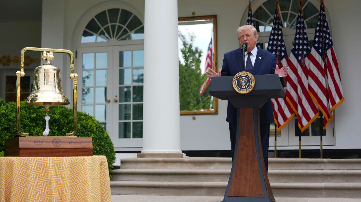 President Donald Trump speaks alongside the New York Stock Exchange bell at a lunch in the White House Rose Garden, Monday in Washington.