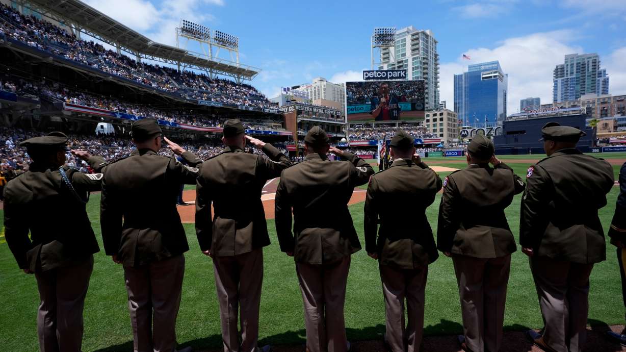 Army recruiters salute during the national anthem before the San Diego Padres host in the New York Yankees in a baseball game, May 26, 2024, in San Diego.