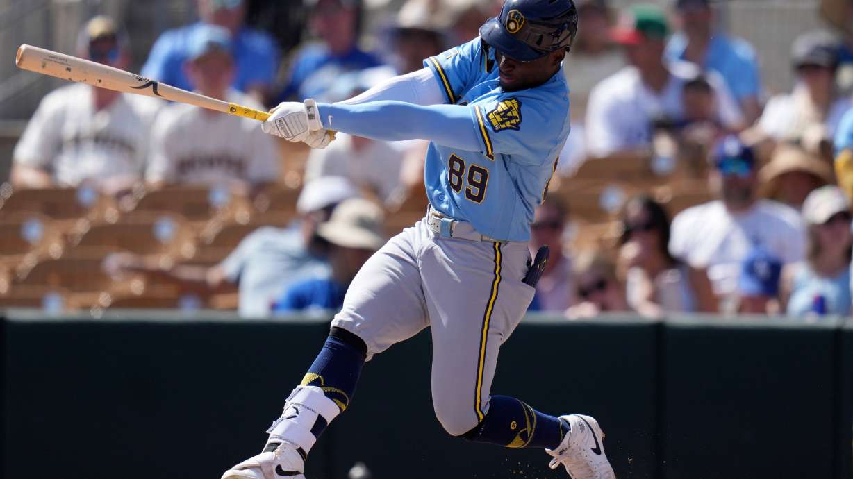 FILE - Milwaukee Brewers' Luis Lara follows through with his swing against the Los Angeles Dodgers during the third inning of a spring training baseball game, Monday, March 16, 2026, in Phoenix.