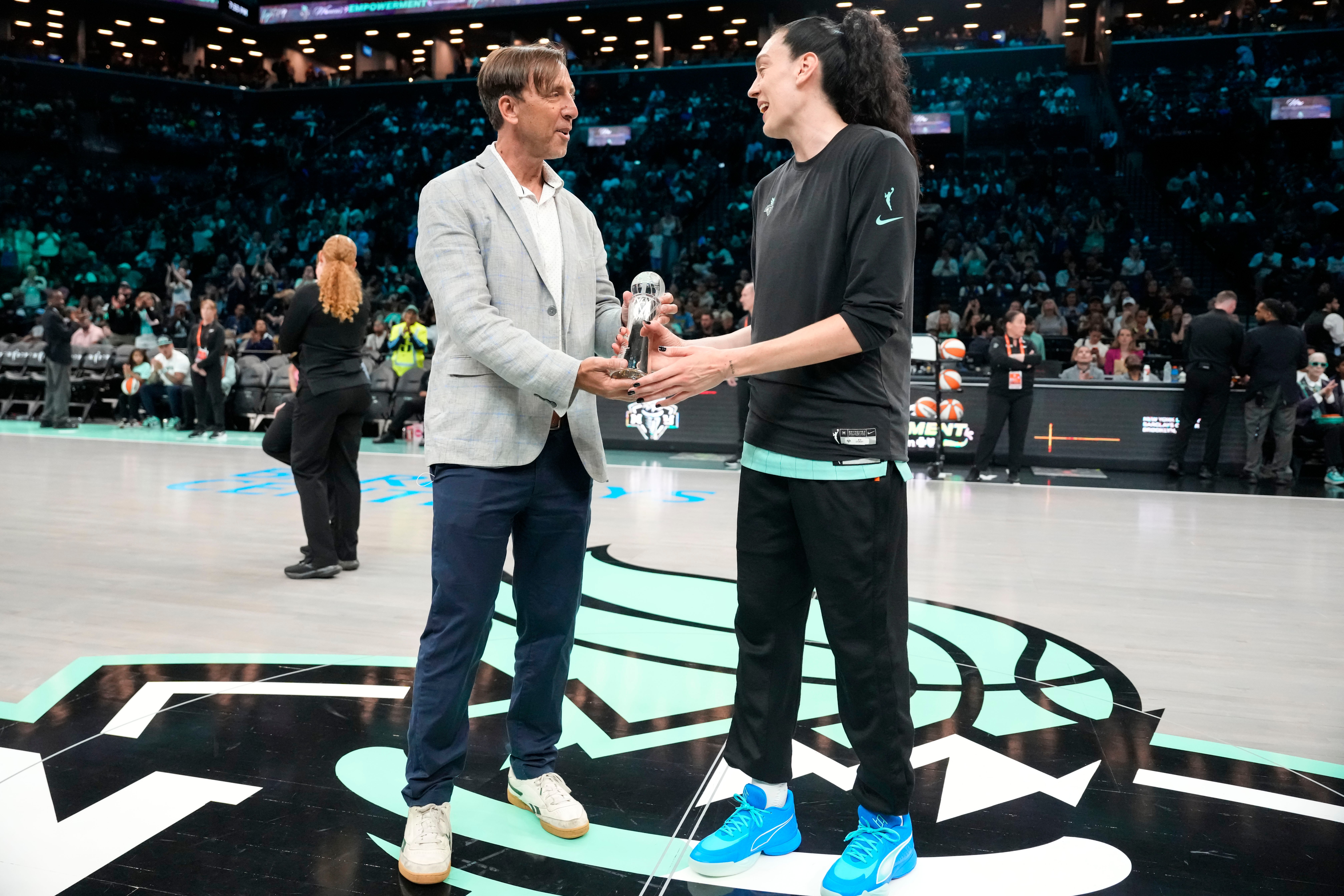 The Associated Press' Global Sports Editor Josh Hoffner presents the Greatest Player award to New York Liberty forward Breanna Stewart ahead of a WNBA basketball game against the Dallas Wings, Tuesday, July 7, 2026, in New York. 
