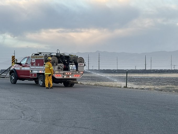 A Utah Fire Authority firefighter sprays water on a grass fire near I-80 and 7200 West on Wednesday, July 8, 2026.