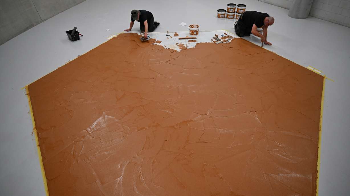 Workers spread peanut butter on a floor to recreate the "Peanut Butter Floor" artwork in tribute to Dutch artist Wim T. Schippers at the Museum Boijmans Van Beuningen in Rotterdam, Netherlands, Friday.