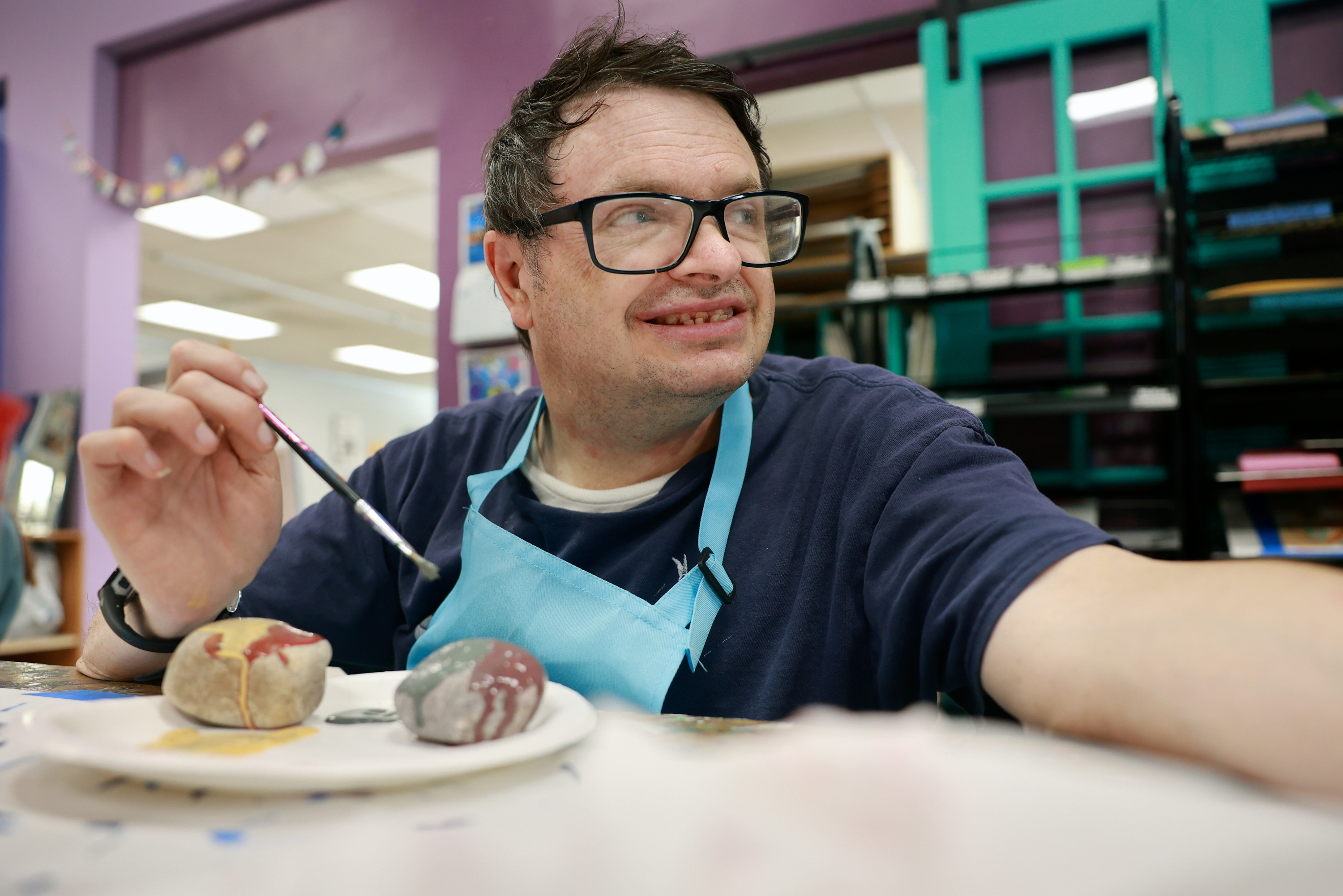 Tony LeFevre paints rocks before volunteering at Jump the Moon art studio in Logan on Tuesday. It is one of the few volunteer jobs he does through the Cache Employment and Training Center, and he can pair it with an art activity while at Jump the Moon.