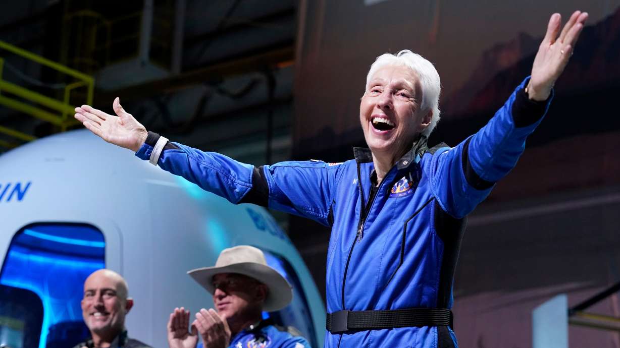 Wally Funk, right, describes her flight experience as Mark Bezos, left, and Jeff Bezos, left, center, applaud in the spaceport near Van Horn, Texas, July 20, 2021. Wally Funk, an aviation pioneer who was the oldest woman to launch into space, has died.