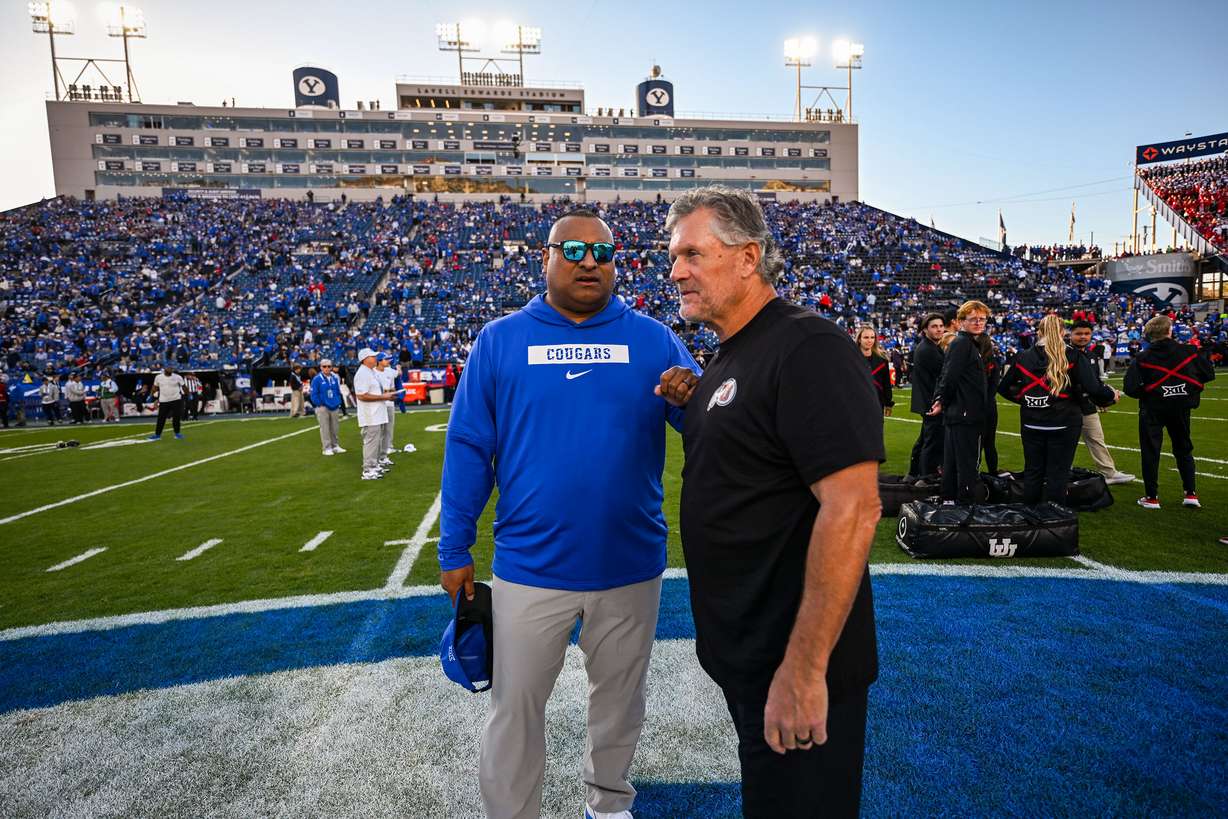 BYU head coach Kalani Sitake and Utah head coach Kyle Whittingham talk prior to BYU and Utah playing at LaVell Edwards Stadium in Provo on Saturday, Oct. 18, 2025.