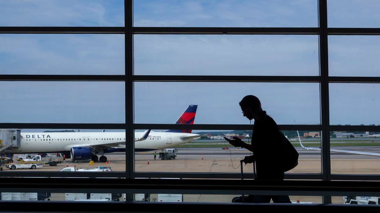 A passenger walks through the terminal at Ronald Reagan Washington National Airport. Strong demand for travel should keep airfares high the rest of this year, according to Delta.