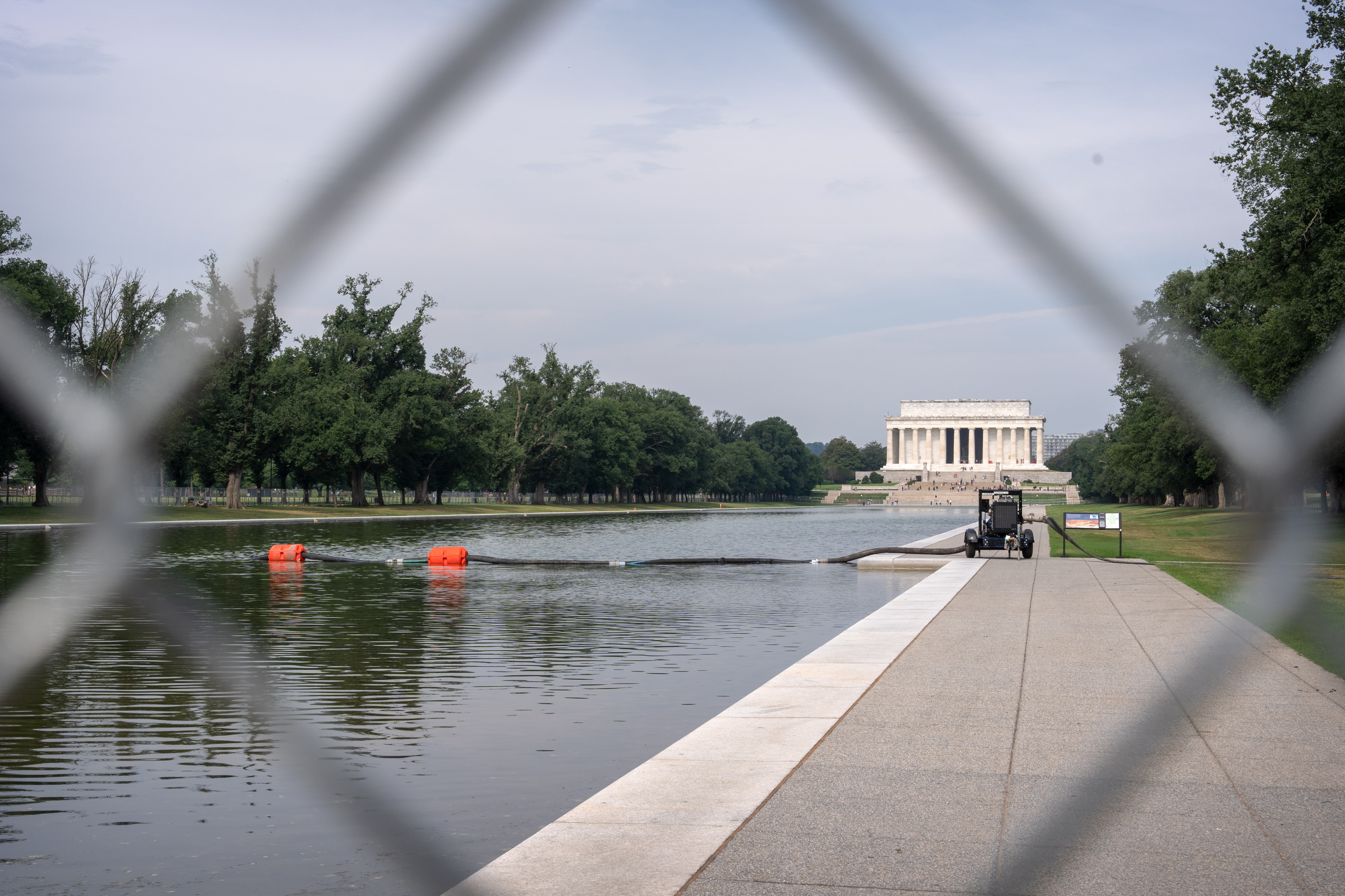A pump connected to a hose is placed next to the Lincoln Memorial Reflecting Pool, Friday, in Washington.