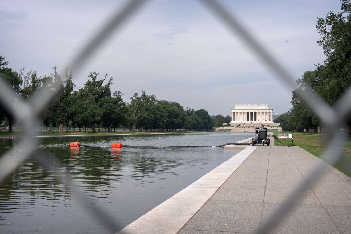 A pump connected to a hose is placed next to the Lincoln Memorial Reflecting Pool, Friday, in Washington.