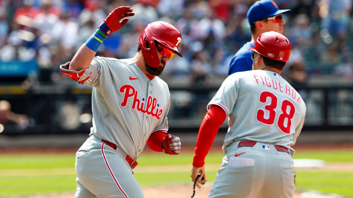 Philadelphia Phillies' Kyle Schwarber, left, celebrates with first base coach Paco Figueroa (38) after hitting a two-run home run against the New York Mets during the seventh inning of a baseball game, Sunday, June 28, 2026, in New York.