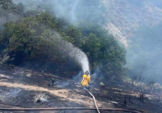 Sandy Fire Department firefighters battle a grass fire at Dimple Dell Regional Park in Sandy on Friday.