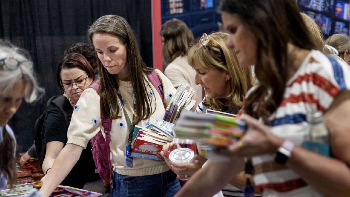Attendees choose free books from Marissa’s Books & Gifts at the Show Up for Teachers/Educator Wellness Conference at the Mountain America Exposition Center in Sandy on Thursday.